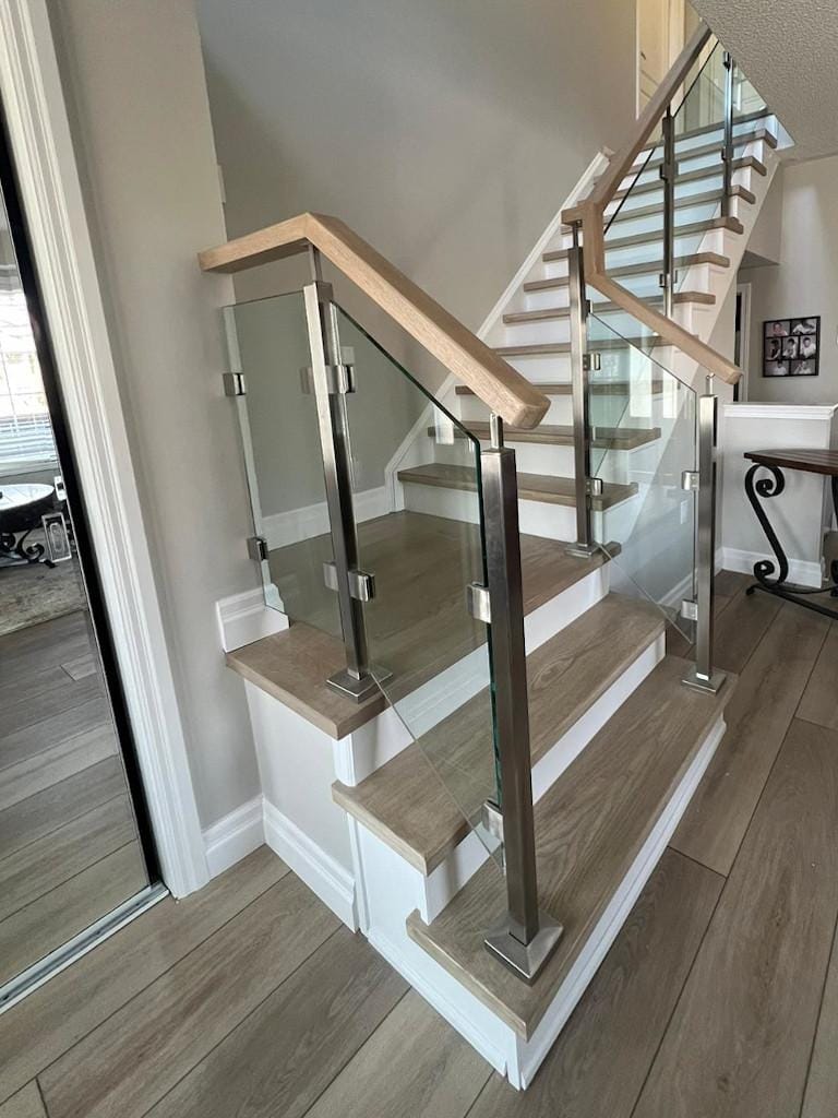 Interior glass handrail with stainless steel newel posts with two tone modern stain finish