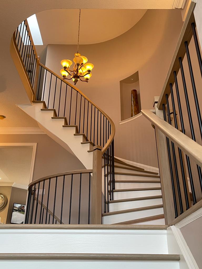 beautiful remodel of an older staircase, adding iron spindles and modern newel posts